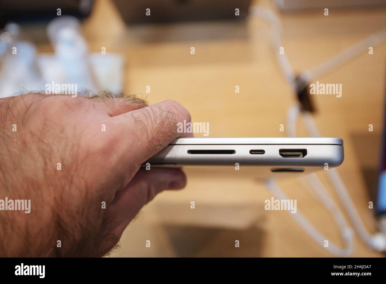 Male hand checking the new sd card, HDMI port of Apple Computers MacBook book pro 16 inch laptop