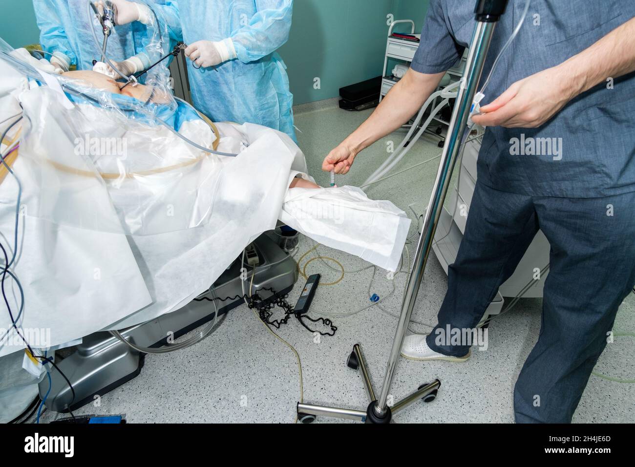 The doctor injects anesthesia into the patient's arm during surgery. Intravenous drip catheter for injecting anesthesia into the patient's arm. General anesthesia during surgery. Stock Photo