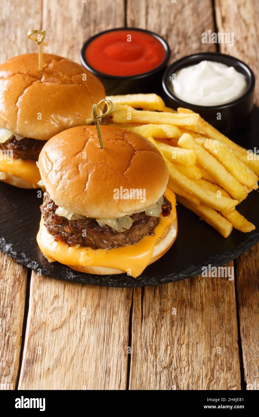 Butter beef burger with French fries close-up on a slate board on the table. Vertical Stock Photo