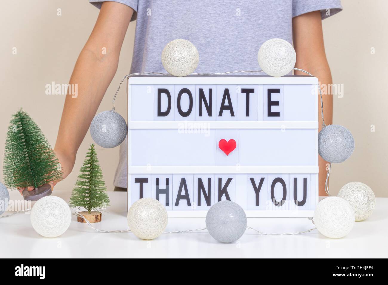 Christmas donation, charity. Kid standing near desk with light box ...