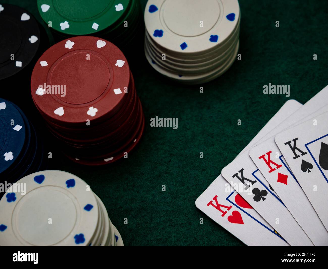 poker game table, four kings with playing chips on the green table Stock Photo