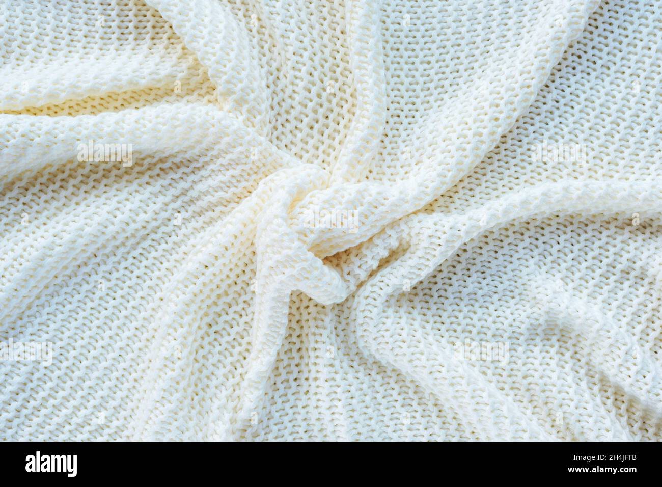 White knitted fabric with curl drape. Texture, background. Stock Photo