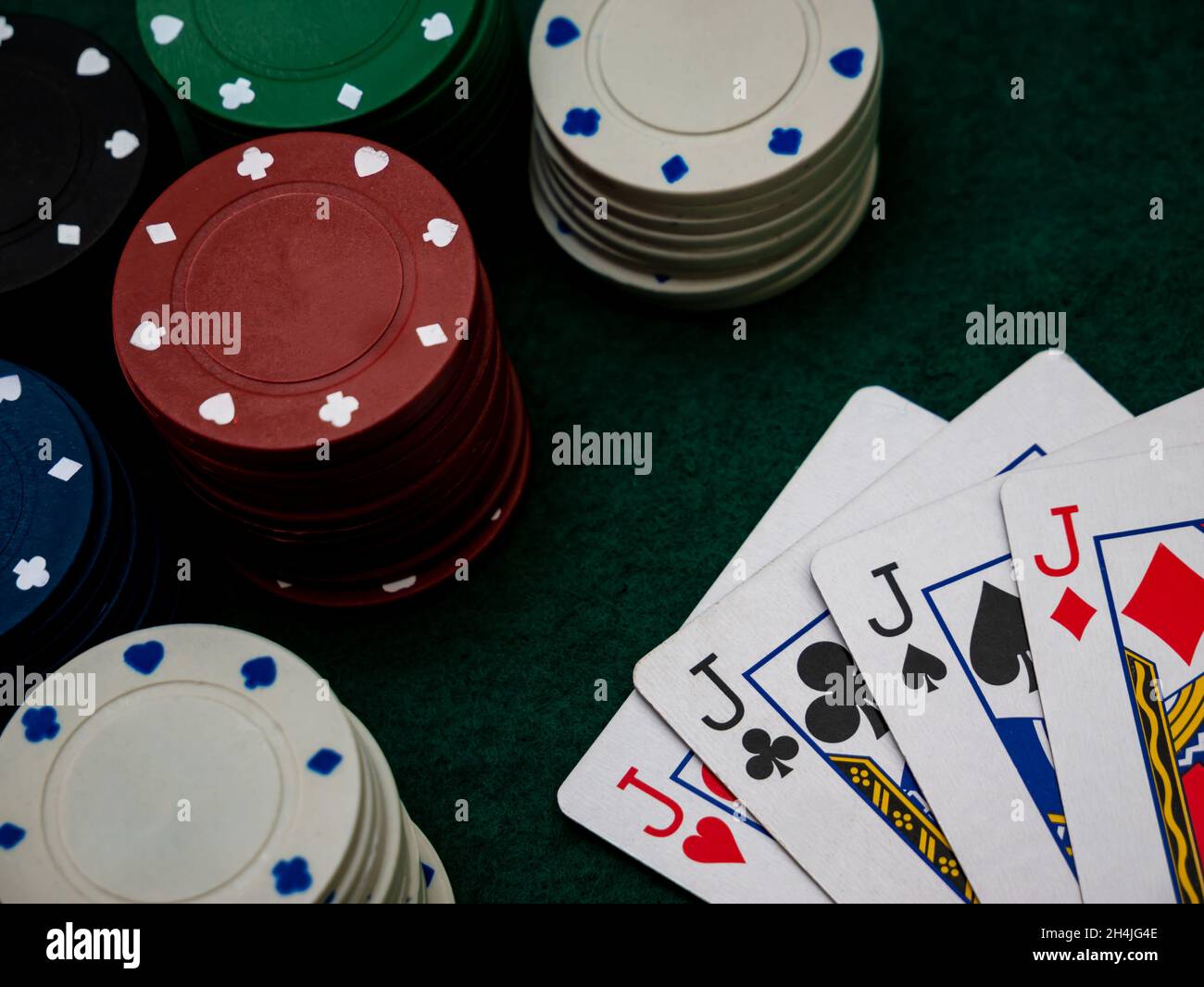 poker game table, four jacks with playing chips on the green table Stock Photo