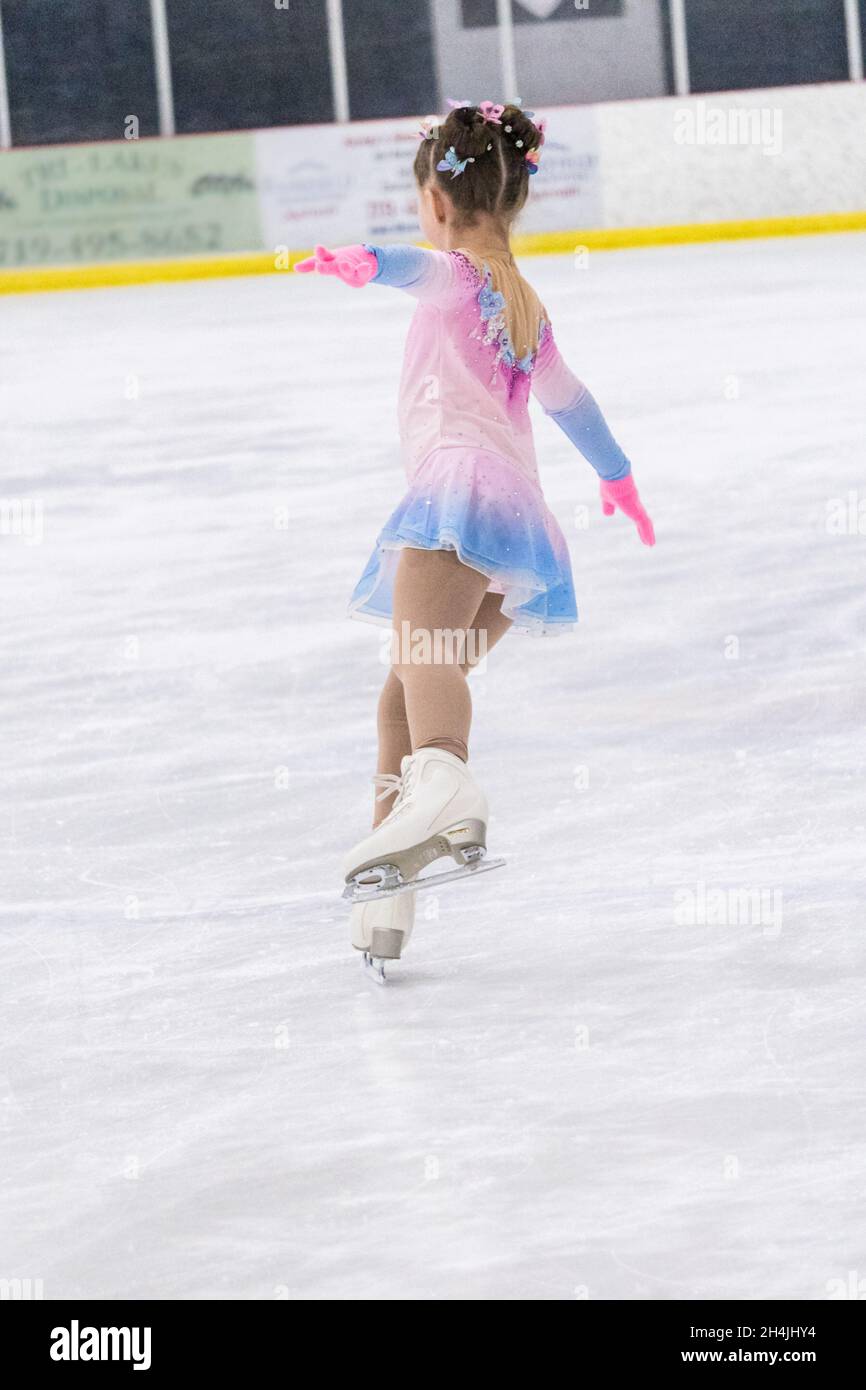 Little girl practicing figure skating on an indoor ice rink Stock Photo ...