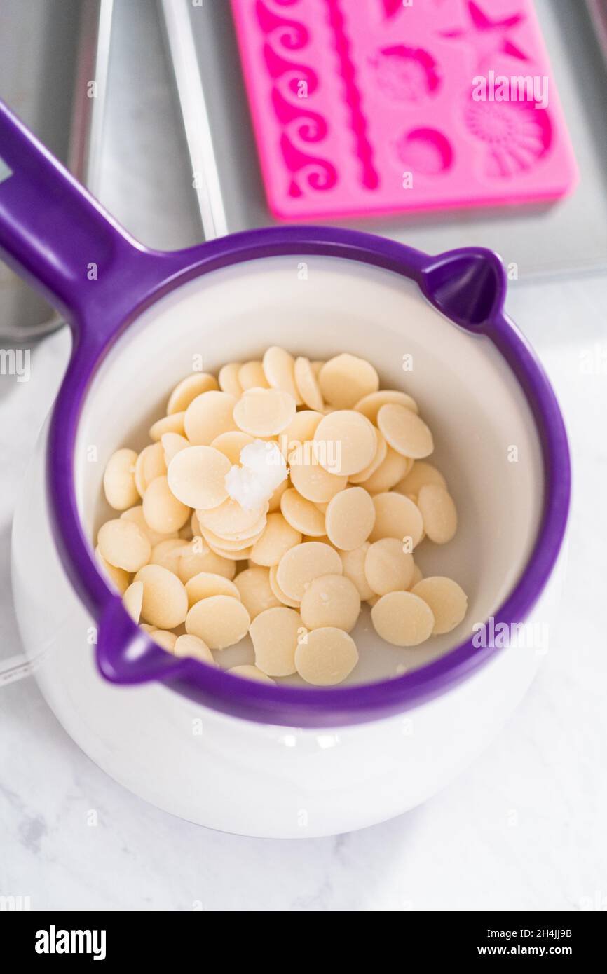 Melting chocolate melts in a candy melting pot to prepare gourmet mini  chocolates with sprinkles Stock Photo - Alamy