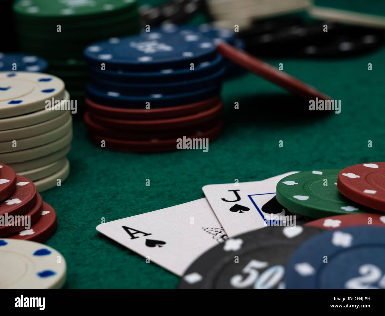 poker game table, ace and jack blackjack score with stack of playing chips on the green table Stock Photo