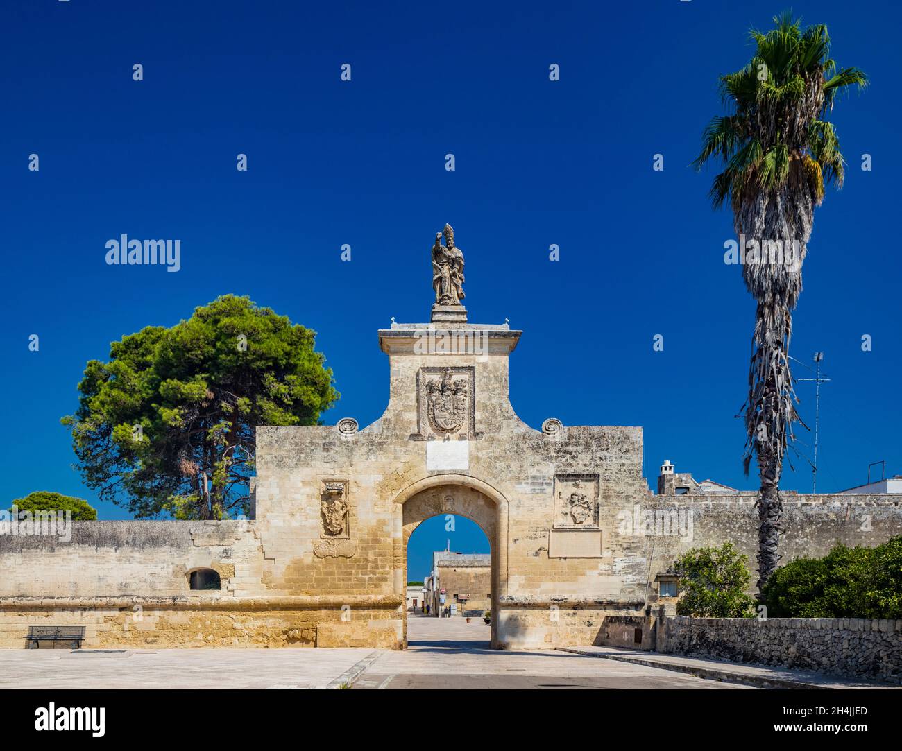 The small fortified village of Acaya, Lecce, Salento, Puglia, Italy. The large stone-paved square. The gateway to the city, with the large arch and th Stock Photo