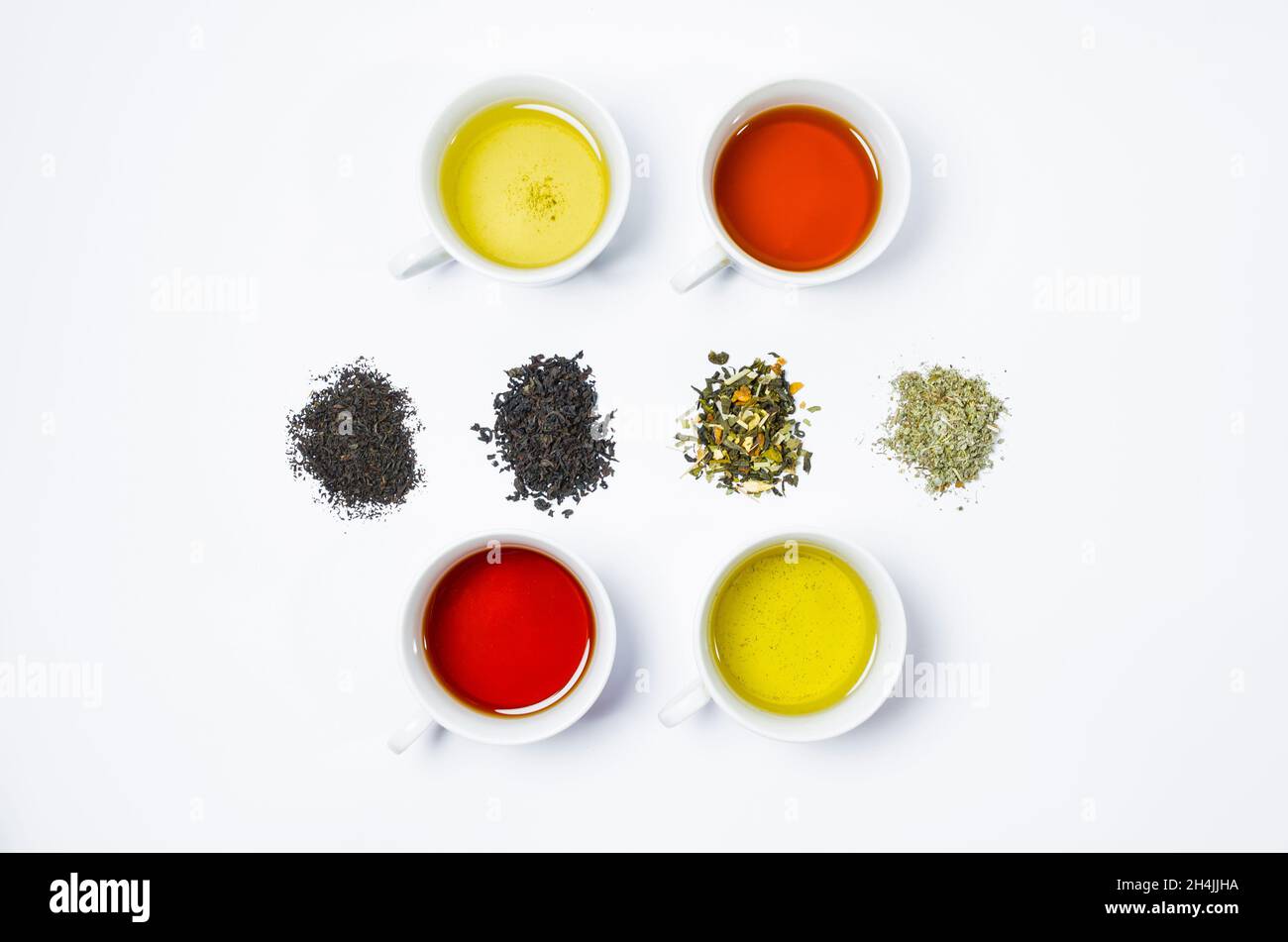 Collection of different teas in cups with tea leaves on a white