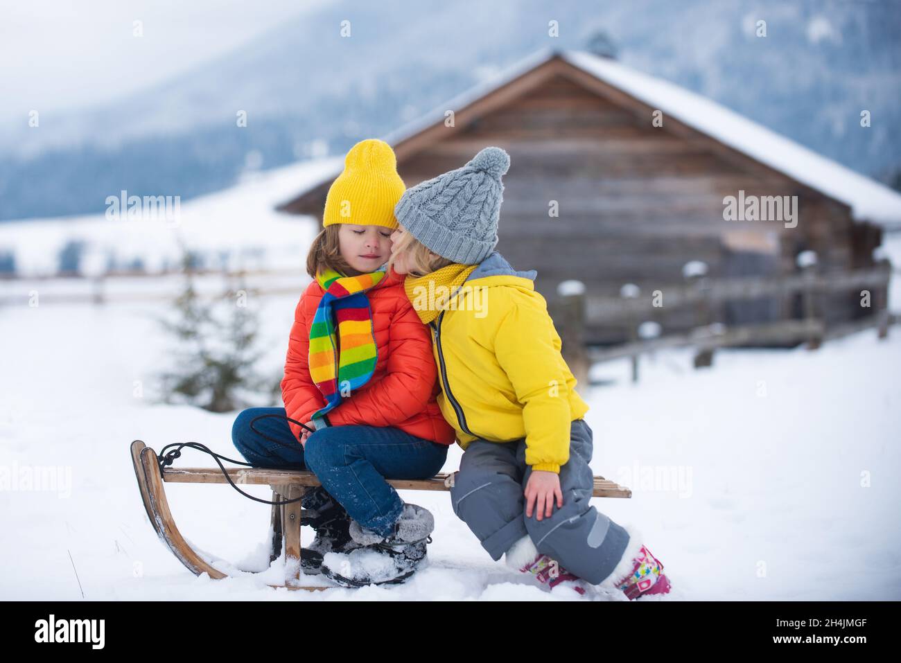 Preschool kid boy in colorful clothes playing outdoors during strong  snowfall. Active leisure with children in winter on cold snowy days. Happy  child having fun, playing with snow. Winter fashion. Stock Photo