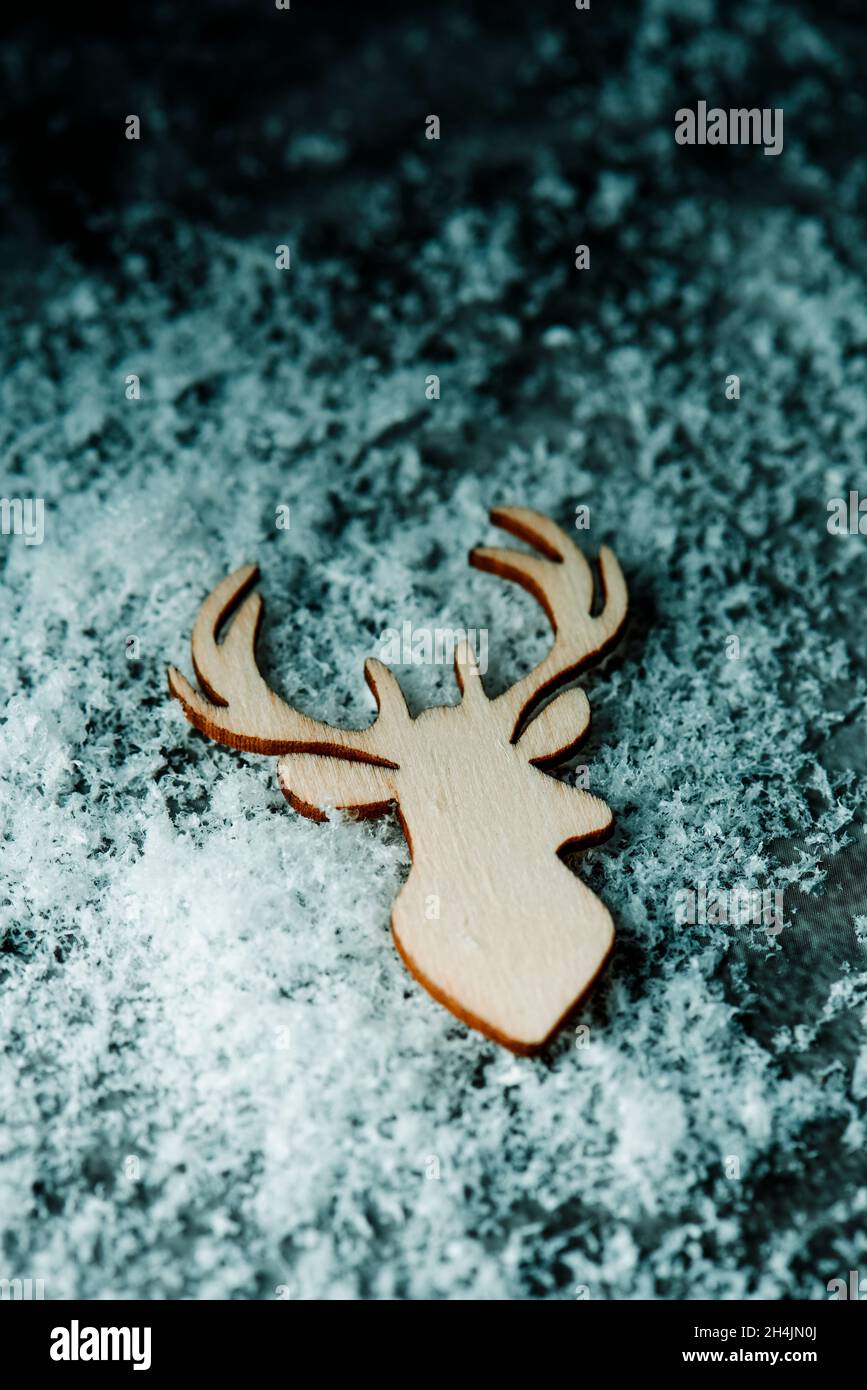 high angle view of the silhouette of a reindeer head cut out on wooden on a pile of snow Stock Photo