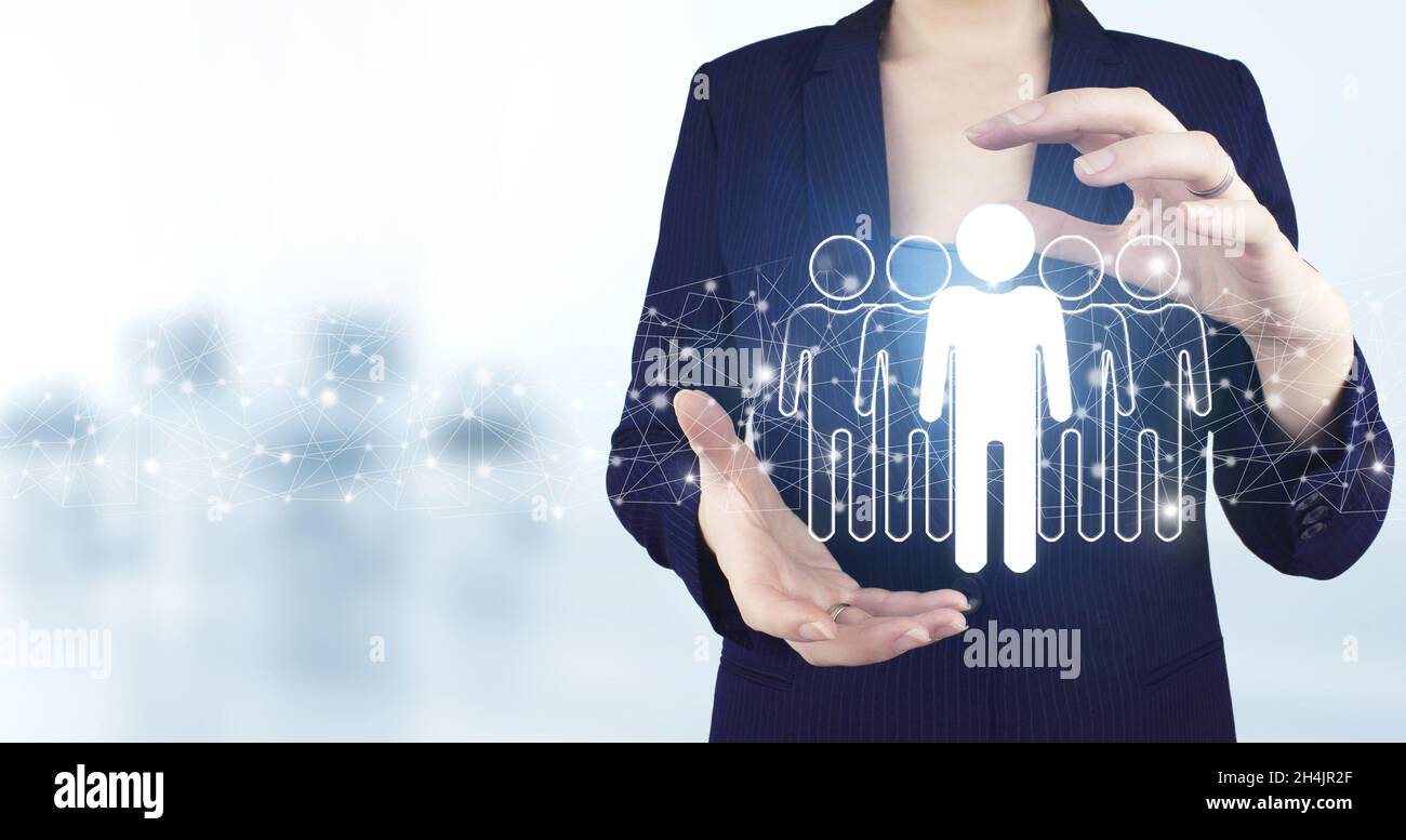 Social media concept. Communication network. Two hand holding virtual holographic Human, Leader icon with light blurred background. HR Human Resources Stock Photo
