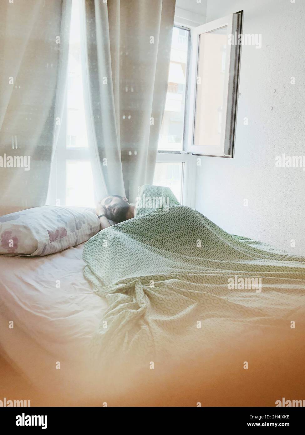 Man lying in bed sleeping by an open window Stock Photo Alamy