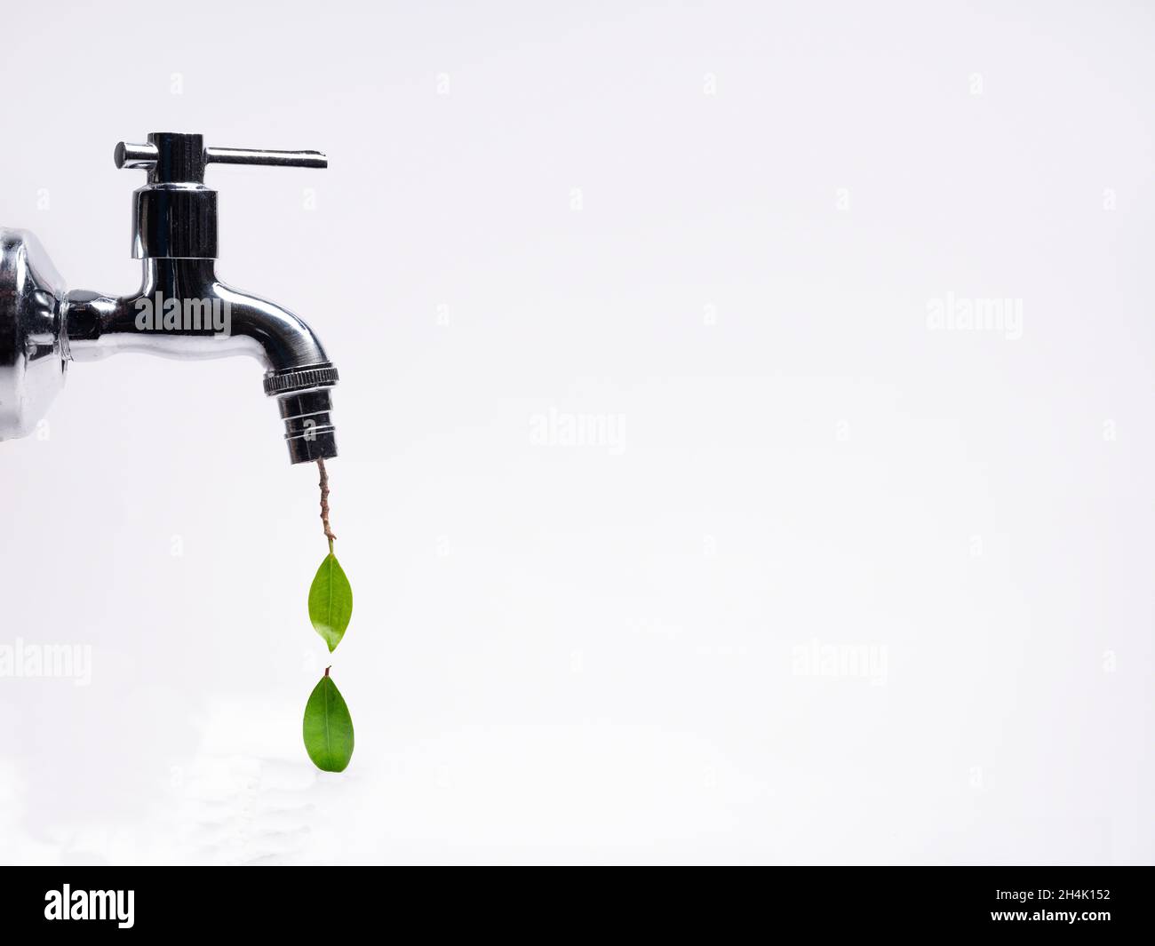 Conceptual water droplets dripping from a tap Stock Photo