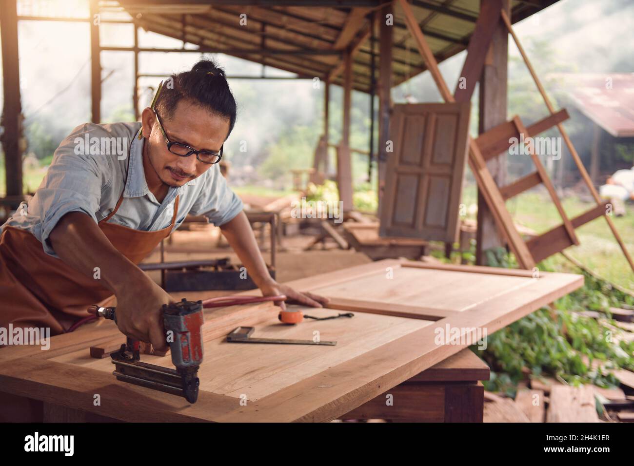 Close-up of a carpenter making furniture using a nail gun Stock Photo