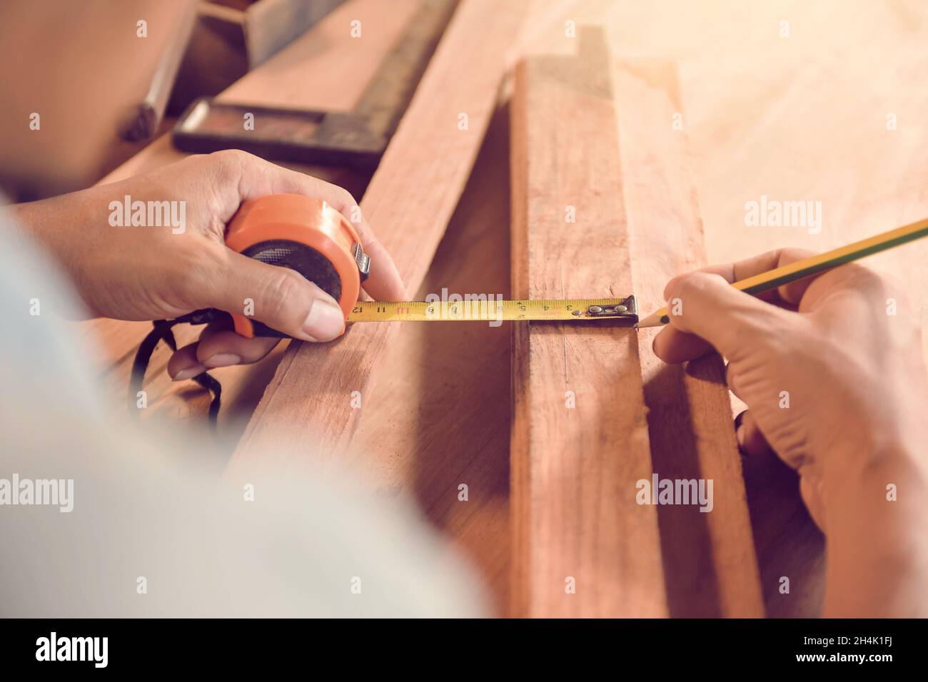 Carpenter measuring a piece of wood in his workshop Stock Photo
