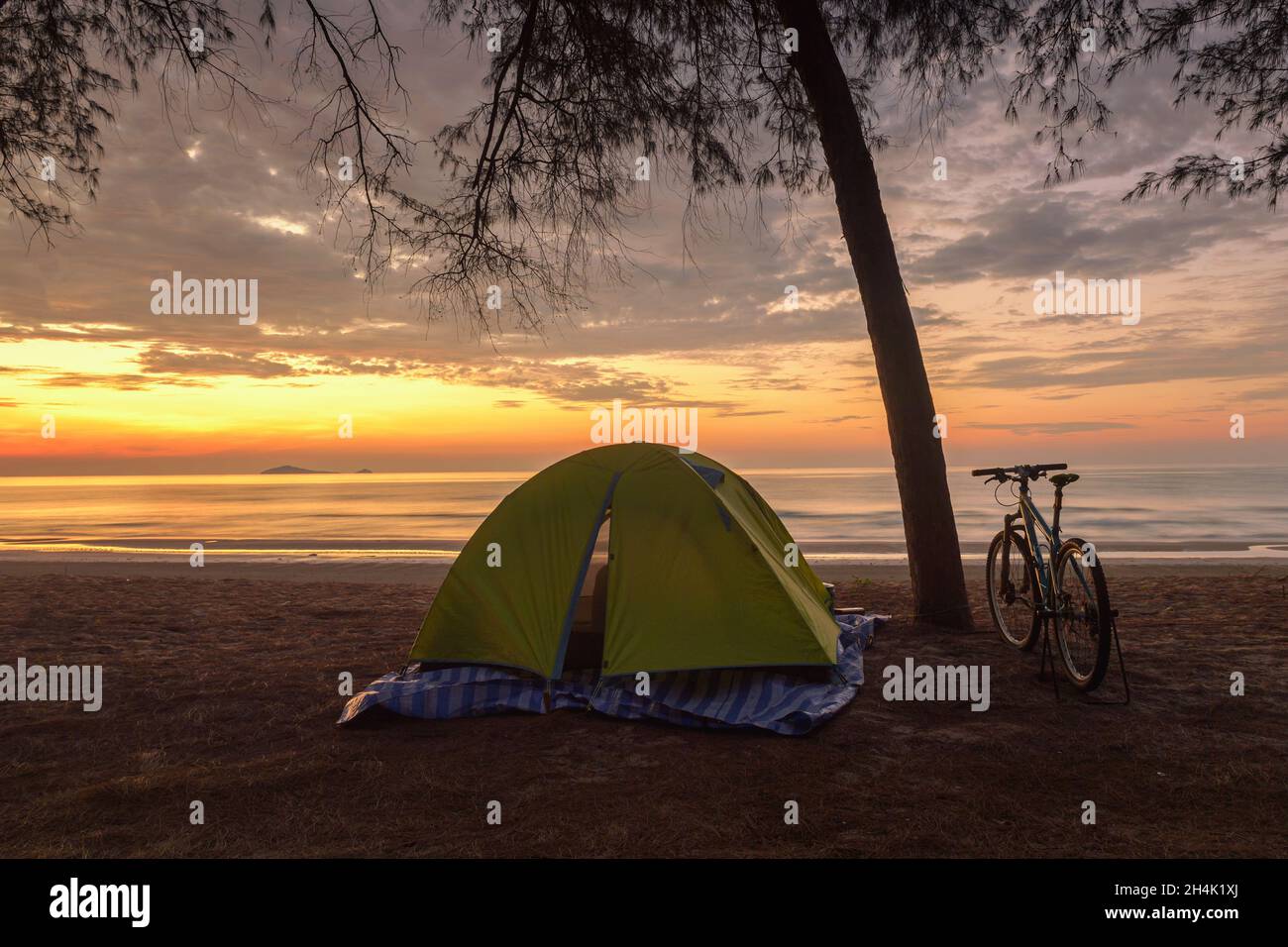 Bicycle parked by a tree and a tent on an empty beach, Wannakorn beach, Petburi province, Thailand Stock Photo