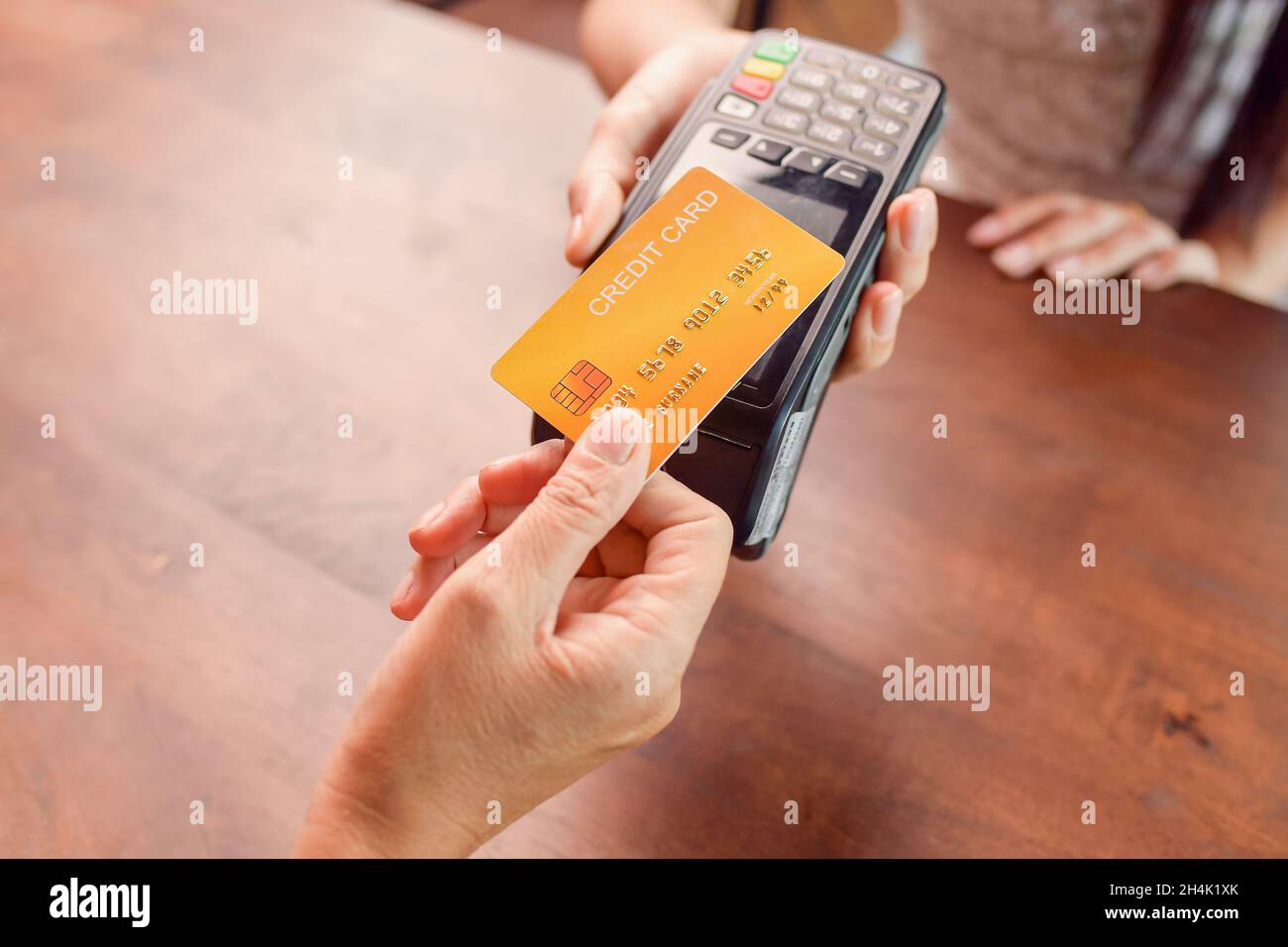 Person paying with a  credit card using a credit card terminal Stock Photo