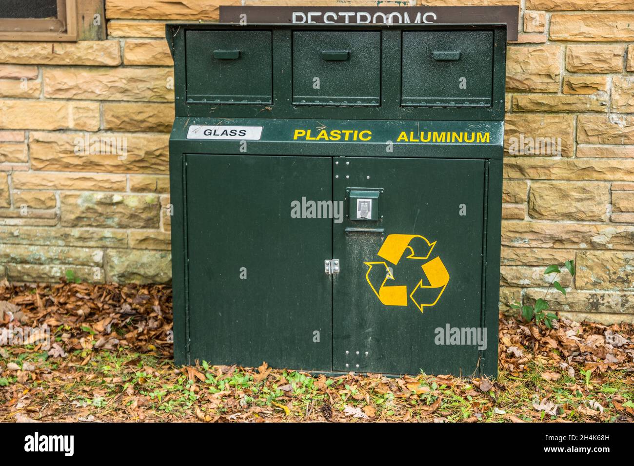 Large recycle garbage bin with separate compartments for glass plastic and aluminum behind the restroom building at the state park closeup Stock Photo