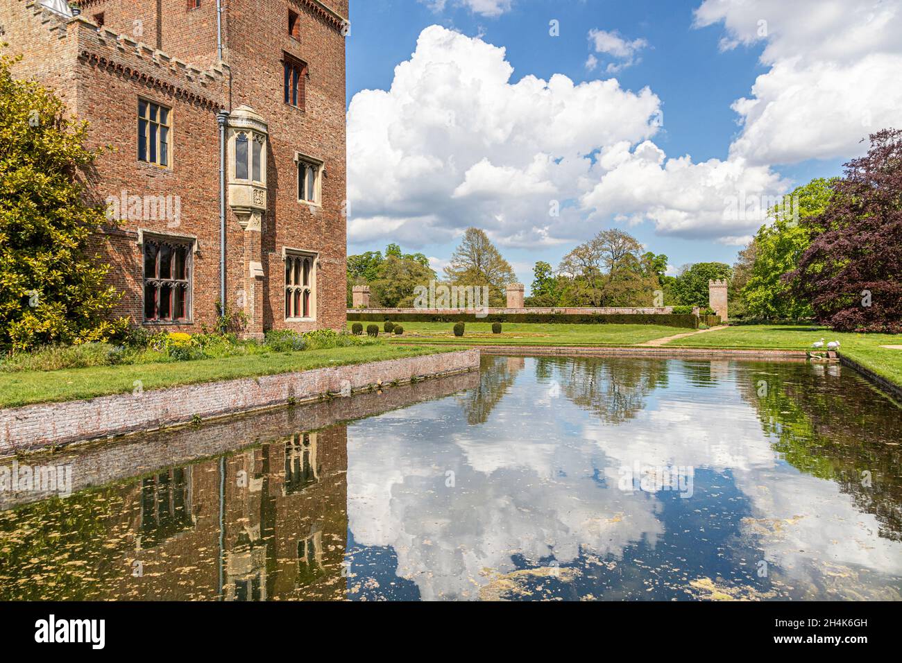 Maytime clouds reflected in the moat of the late medieval Oxburgh Hall, Norfolk UK Stock Photo