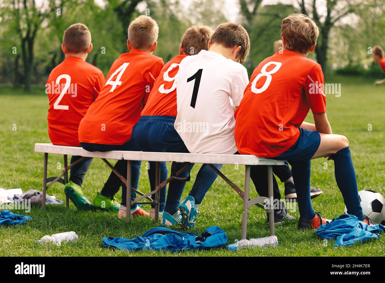 Happy Friends in Sports Team. Group of Young Boys Kicking Sports Soccer Game on  Grass Pitch. School Boys Sitting on Sideline Substitute Bench. School Stock Photo