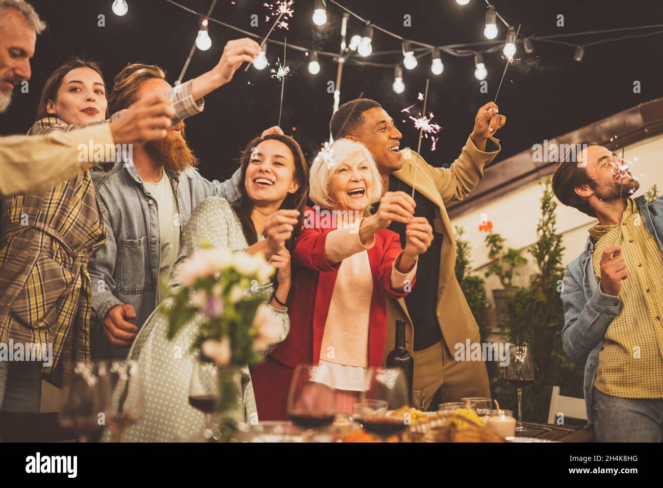 Storytelling footage of a multiethnic group of people dining on a rooftop. Family and friends make a reunion at home. Stock Photo