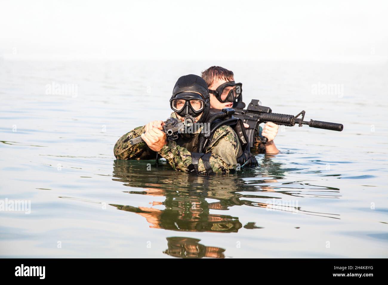 Navy SEAL frogmen with complete diving gear and weapons in the water. Stock Photo