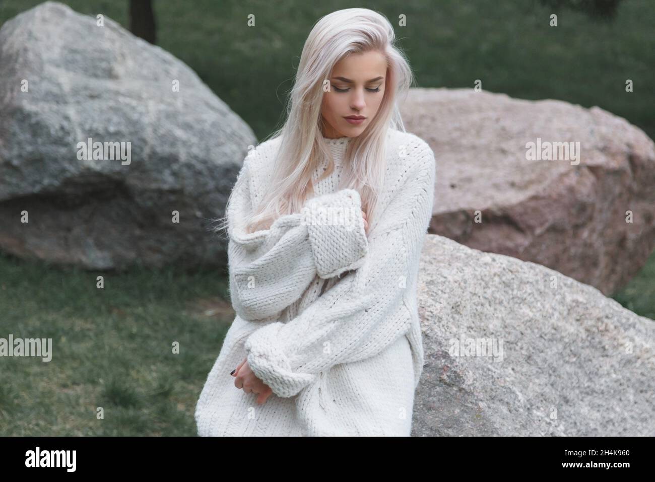 Blonde Hair beautiful female wearing in knitted white sweater. Stock Photo