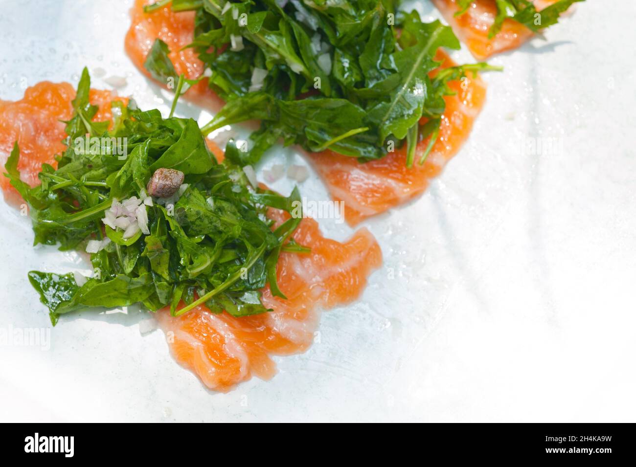 fresh salmon carpaccio sushi sashimi with arugula rocket salad and