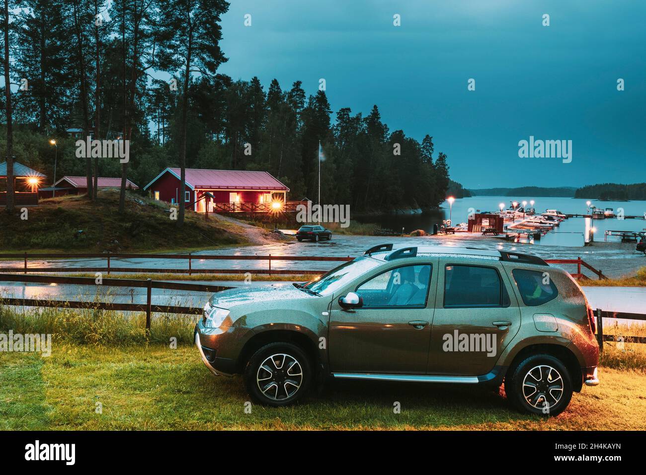 Car SUV Parked Near Lake Or River Landscape In Swedish Countryside Landscape. Summer Evening Night. Stock Photo