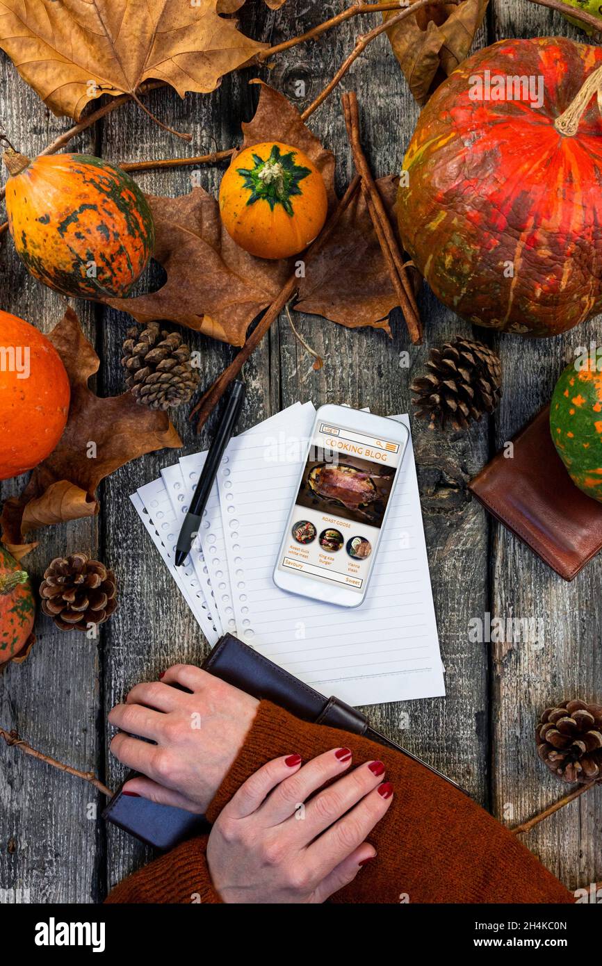 Touchscreen smartphone with online cooking blog on the screen at rustic table in the kitchen. Thanksgiving recipe. Autumn concept cooking. Stock Photo