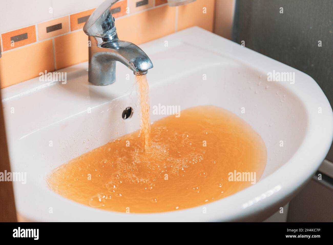 Rusty Water Pours From Tap. Water Pollution. Global Environment Stock