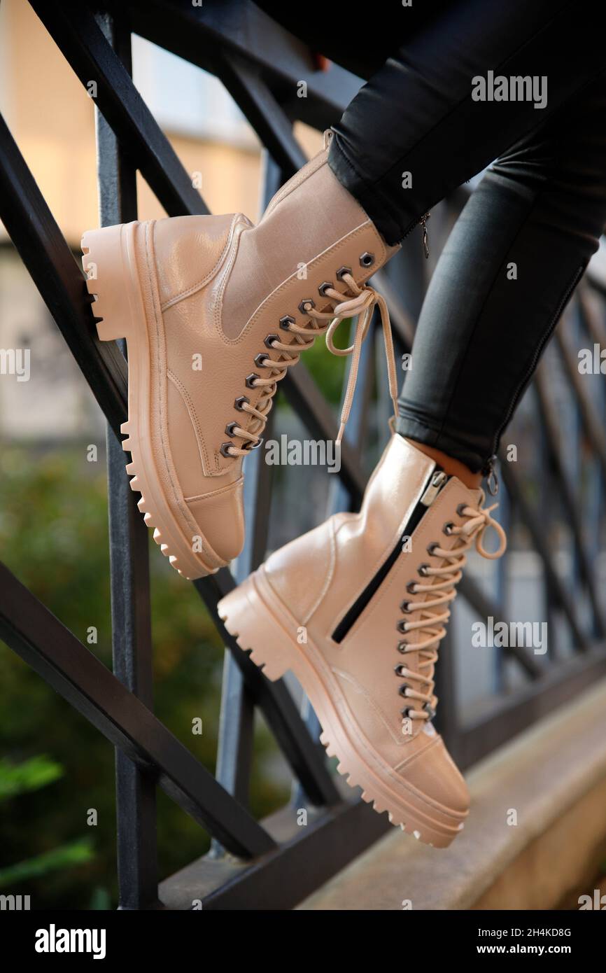 Woman in stylish leather boots and jeans outdoors. Close up of female legs in fashion footwear. Stock Photo