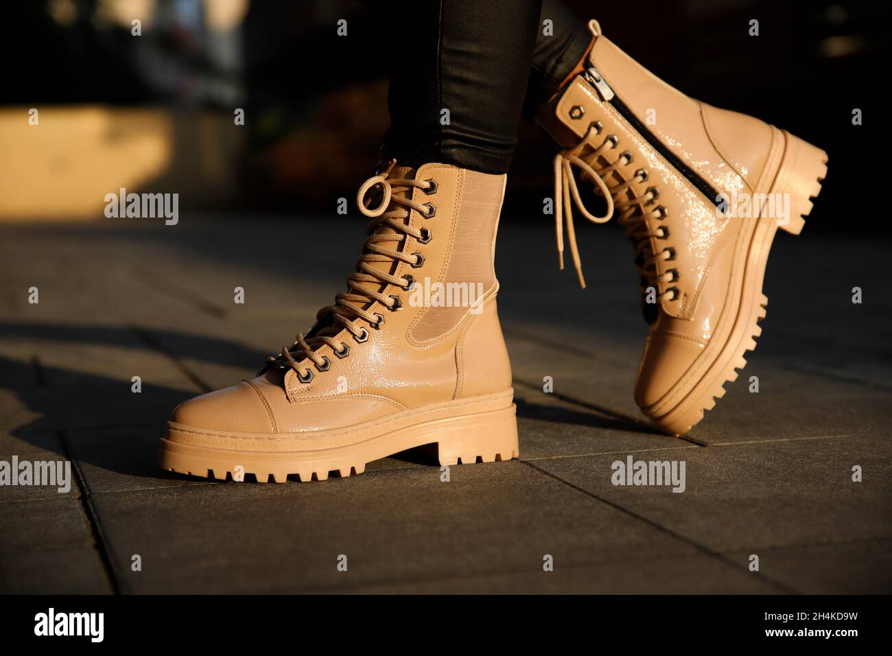 Woman in stylish leather boots and jeans outdoors. Close up of female legs in fashion footwear. Stock Photo
