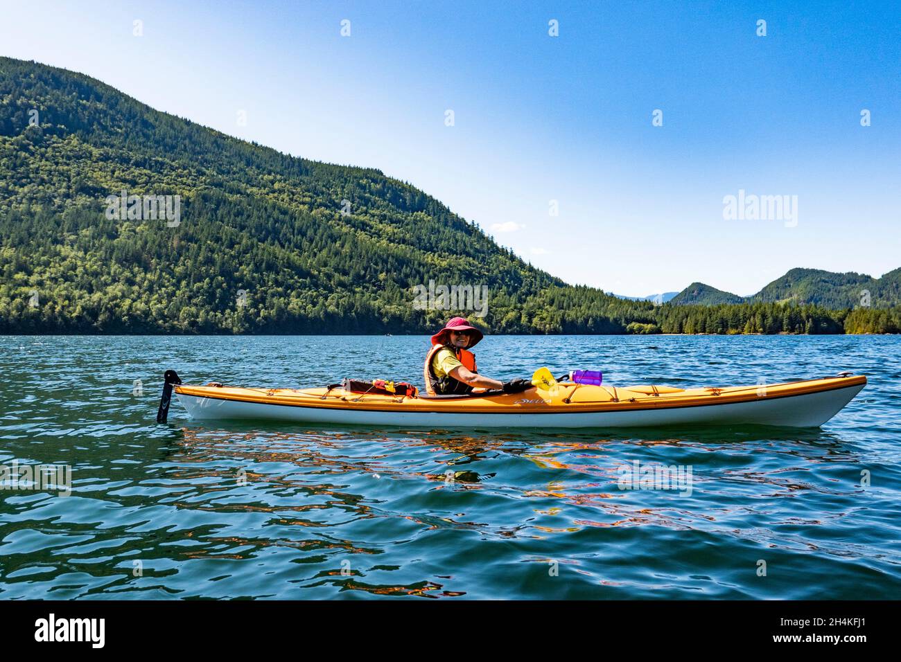 A woman kayaks on Hicks Lake, British Columbia, Canada. Stock Photo