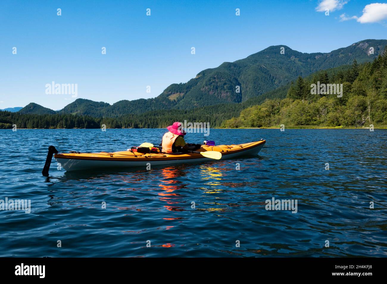 A woman kayaks on Hicks Lake, British Columbia, Canada. Stock Photo