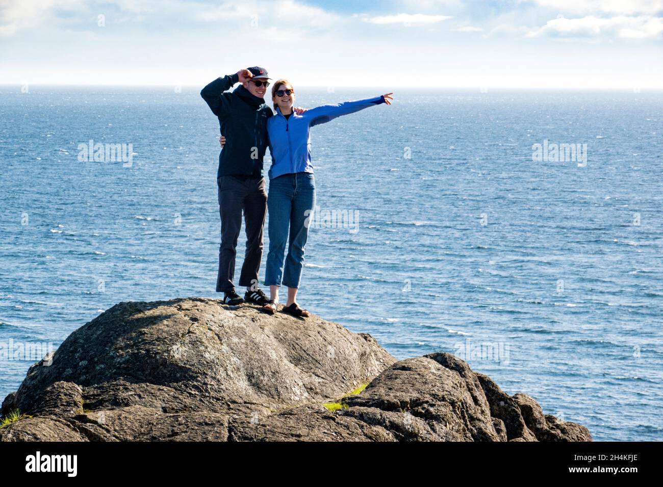 A couple on the rocks by the water in Victoria, BC, Canada. Stock Photo