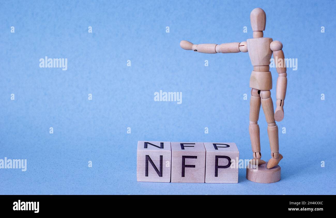The word nfp on a cube with a wooden man on a blue background Stock Photo