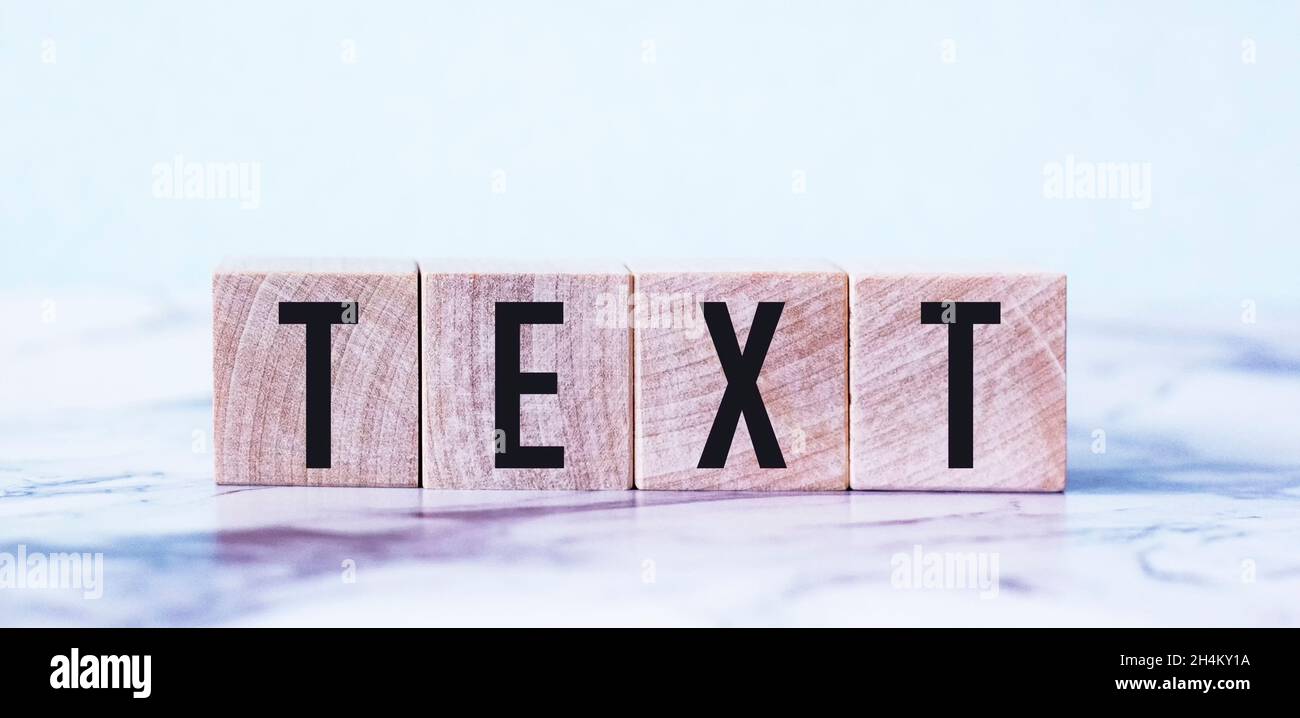 The word TEXT is written on wooden blocks and a light background Stock Photo