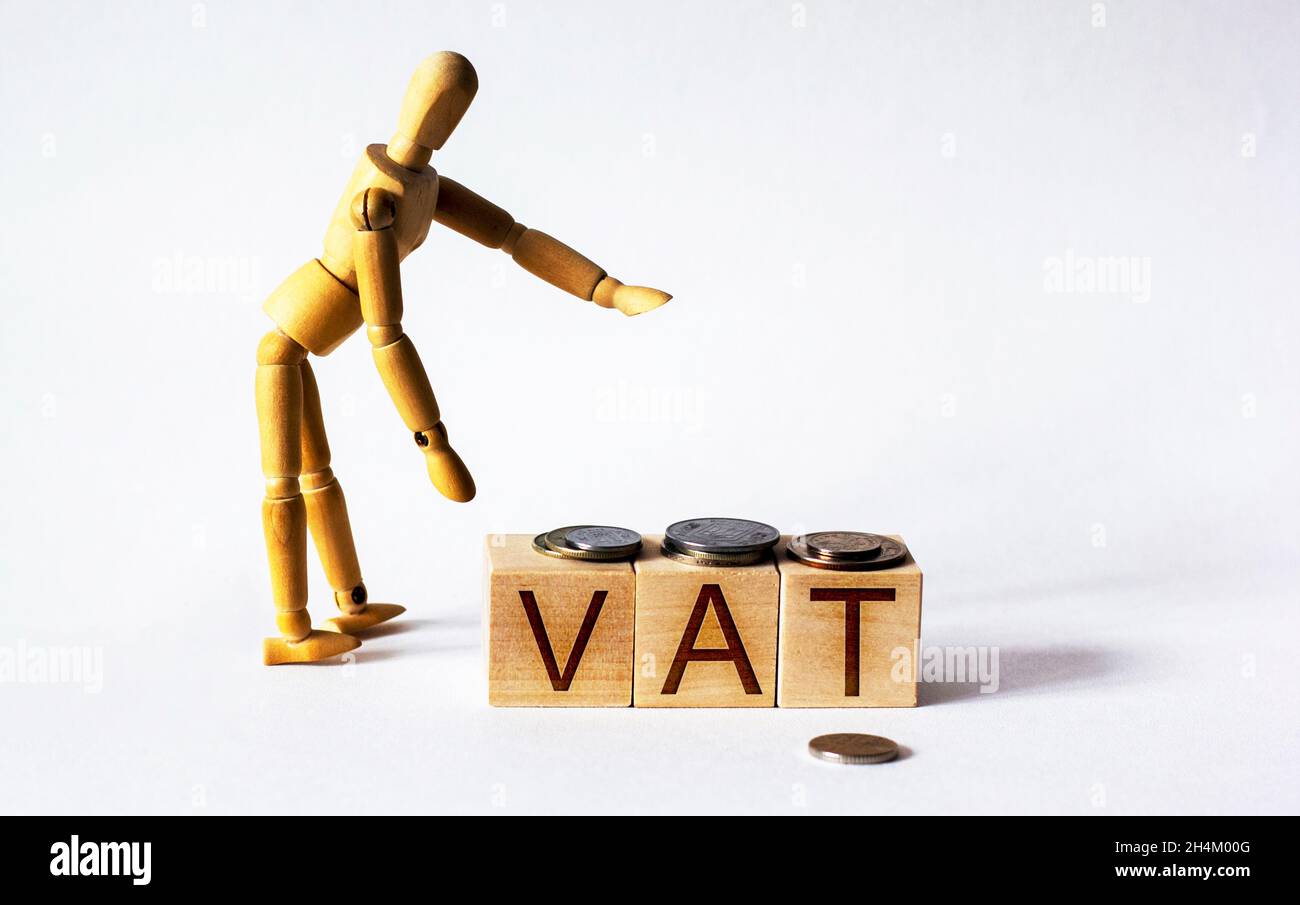text value added tax wooden cubes with doll and coins Stock Photo