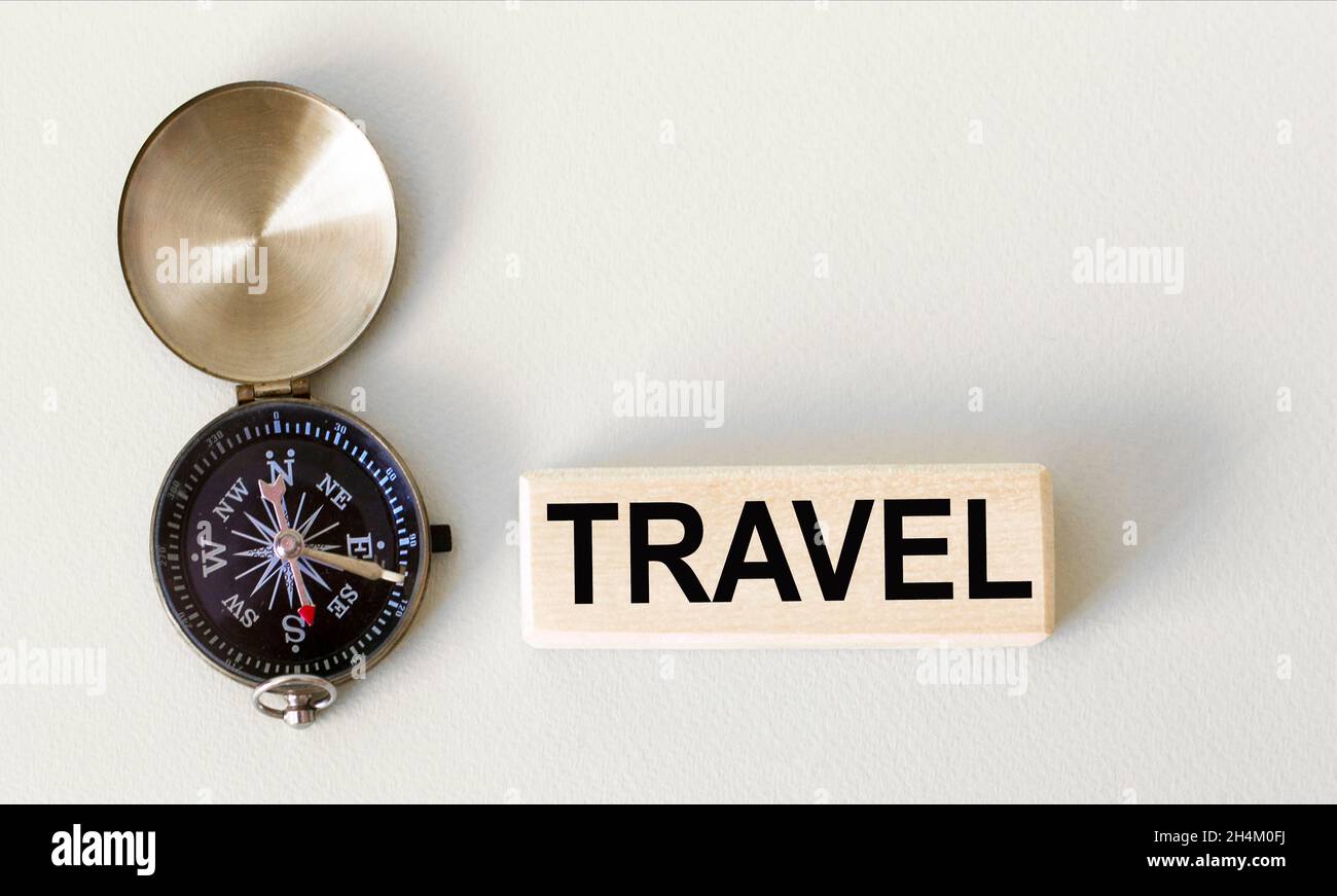 compass on a light background and the text travel on a wooden block Stock Photo
