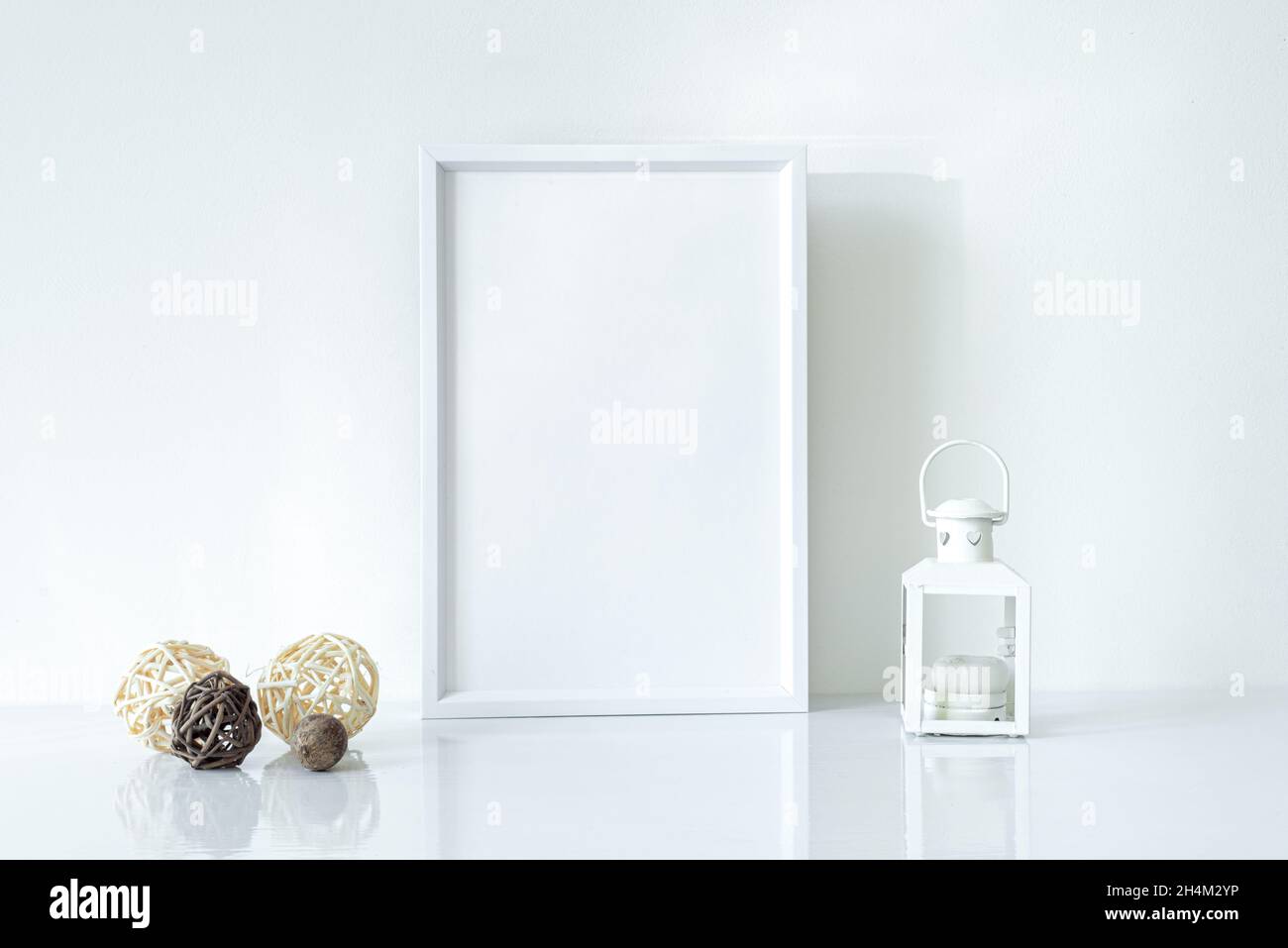 Mock up white frame with Christmas lantern and decorations on shelf. Portrait frame against a white wall Stock Photo