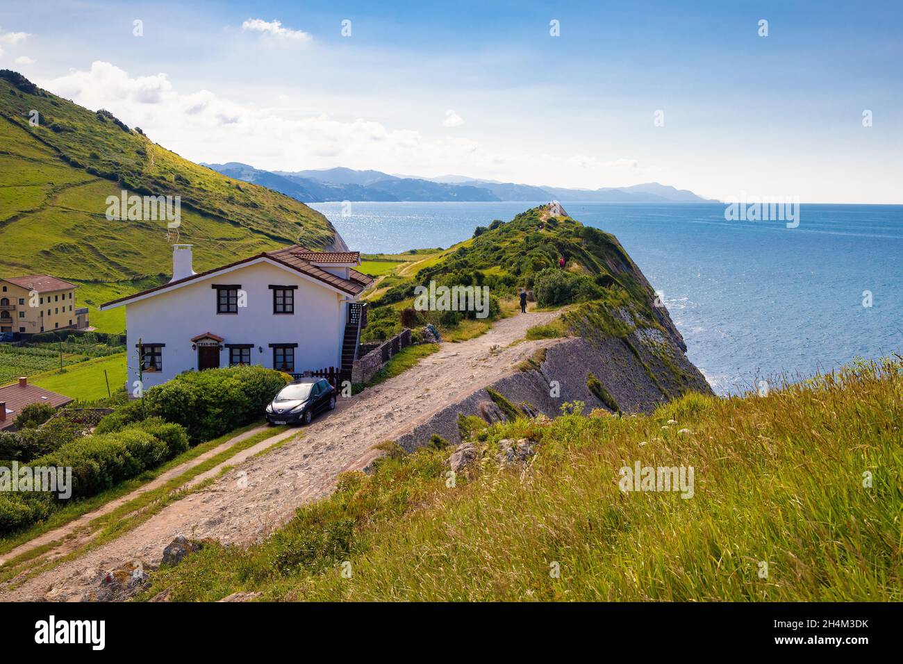View of one of the hiking trails that runs over cliffs through meadows and farmhouses. Zumaya, Euskadi, Spain Stock Photo