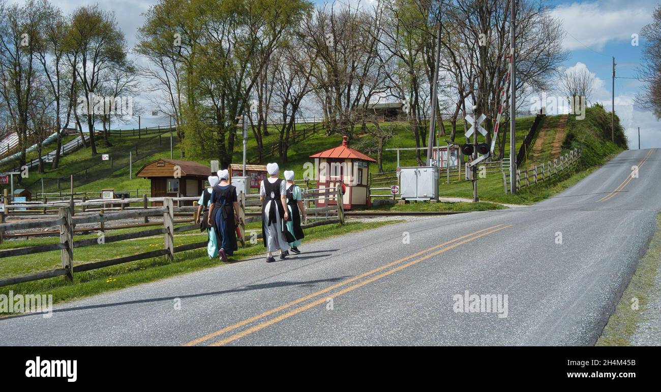 Teenage Amish Boys and Girls Walking Along a Rural Road in the Countryside on a Spring Day Stock Photo