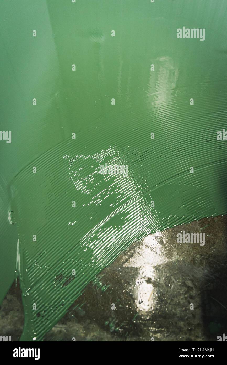 Floor under renovation with green epoxy resin applied over polished