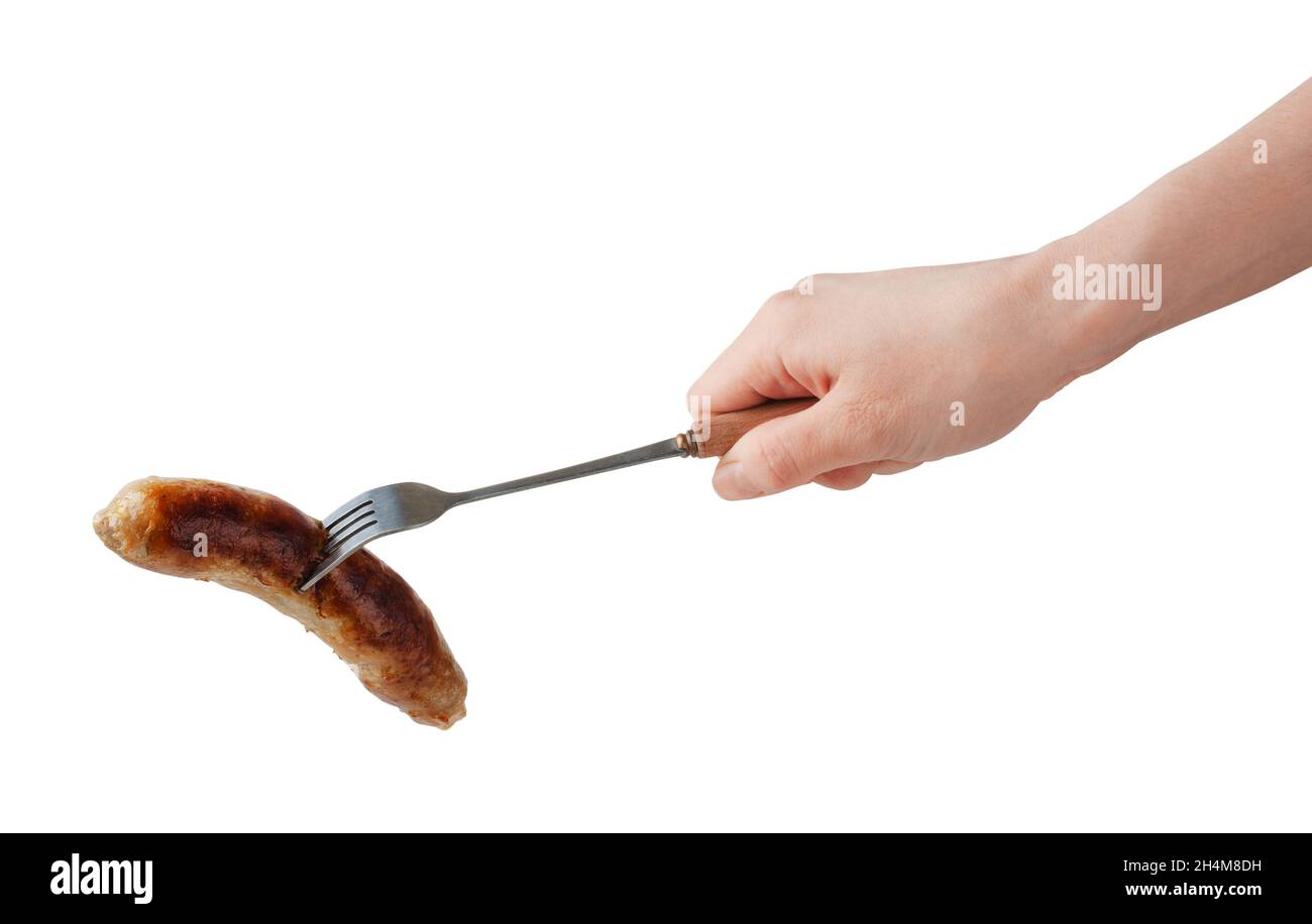 Hand holding barbecue fork BBQ sausage isolated on a white background. Stock Photo