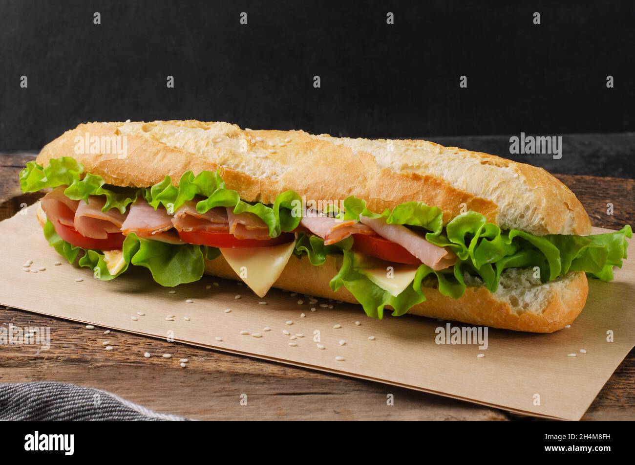 Sandwich with ham, tomato and cheese on a wooden background Stock Photo