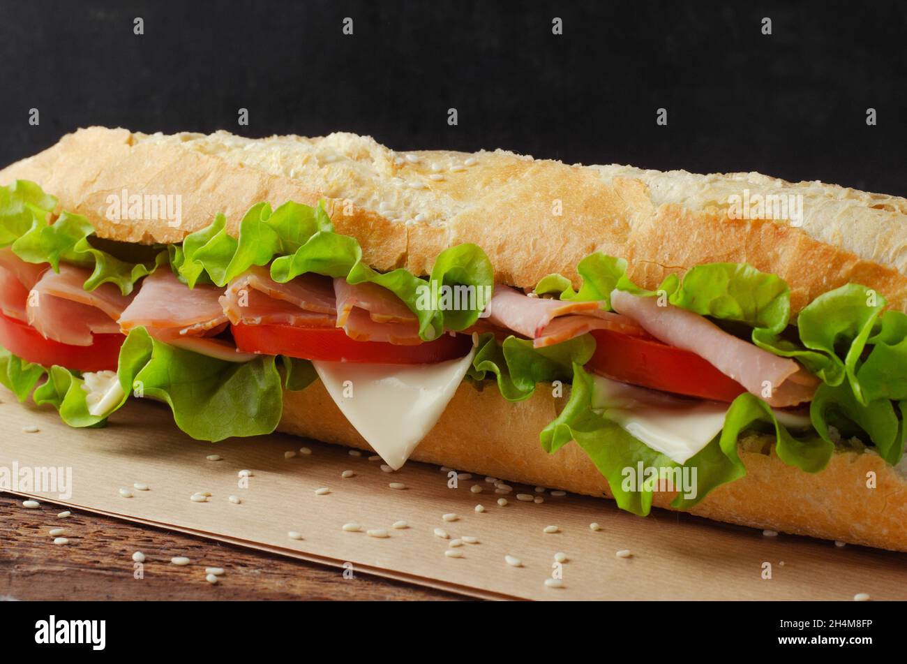 Sandwich with ham, tomato and cheese on a wooden background. Close-up Stock Photo