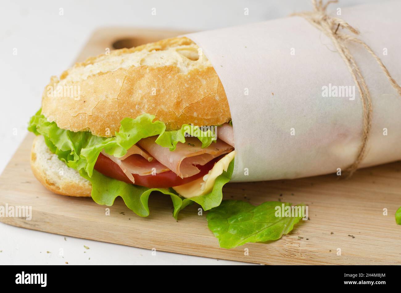 Fresh submarine sandwich with ham, cheese, bacon, tomatoes and salad Stock Photo