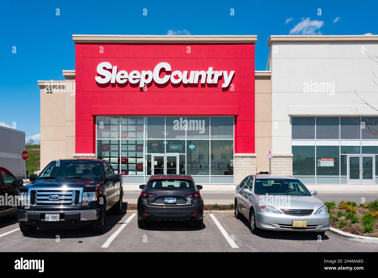 Cars parked in front of a Sleep Country mattress retail store in
