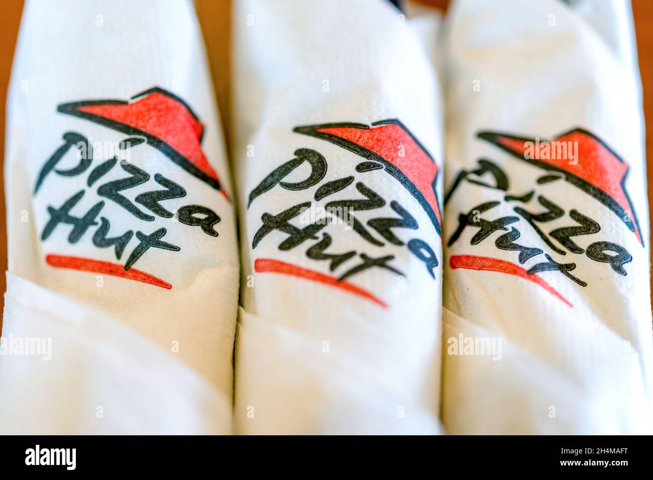 Wrapped cutlery in Pizza Hut branded paper napkins in a restaurant in Toronto Canada.Nov. 2, 2021 Stock Photo